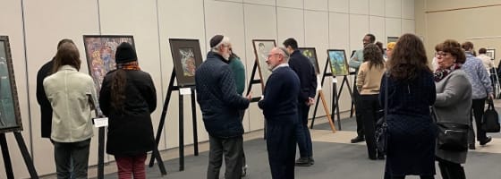 People looking at artwork inside the social hall.