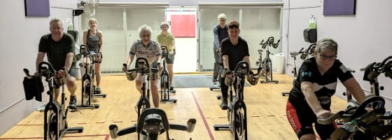 People on spin bikes taking a spin class in the spin facility.